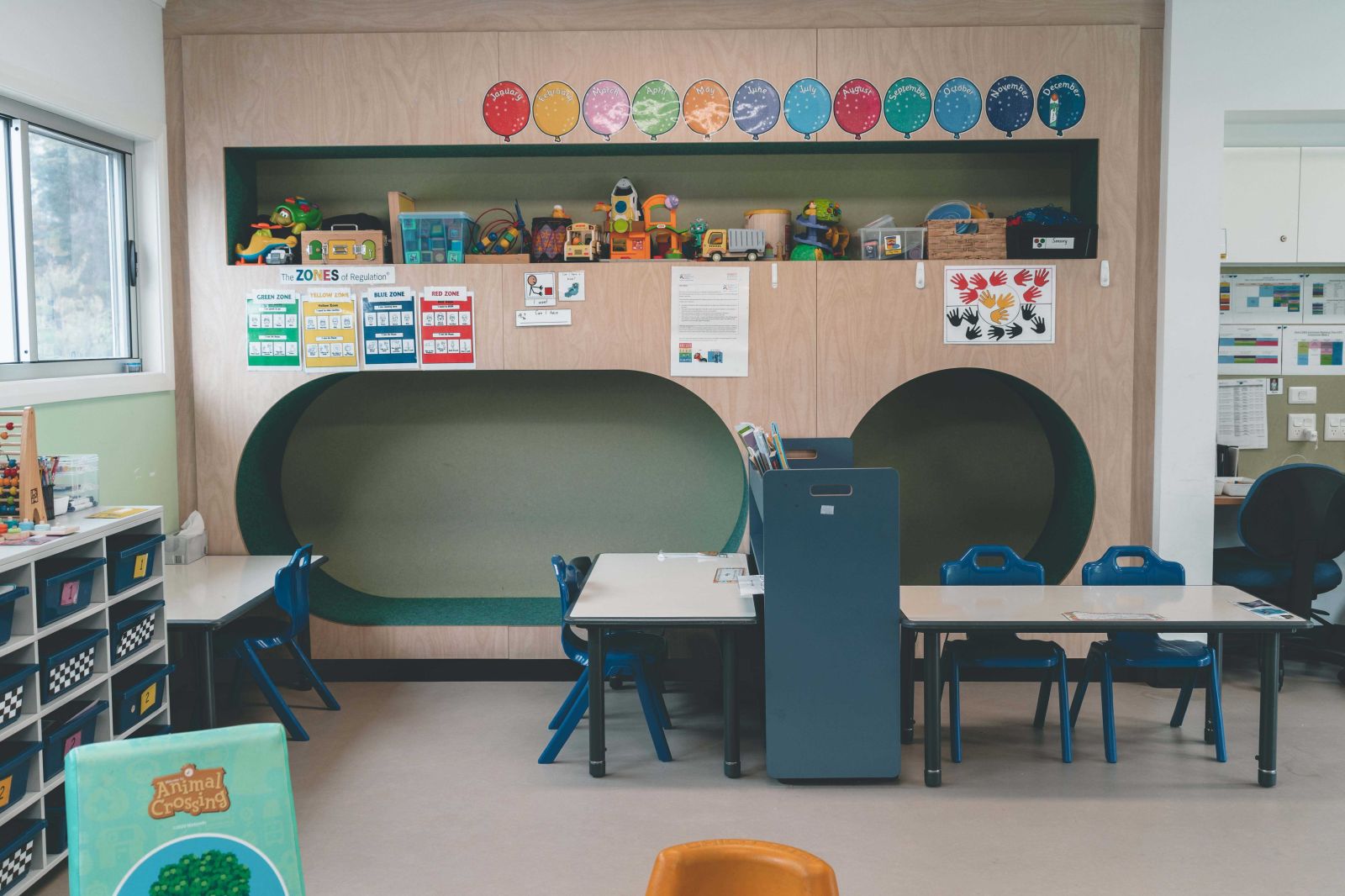 Organised classroom designed for early learning, featuring a variety of educational tools and a cozy layout